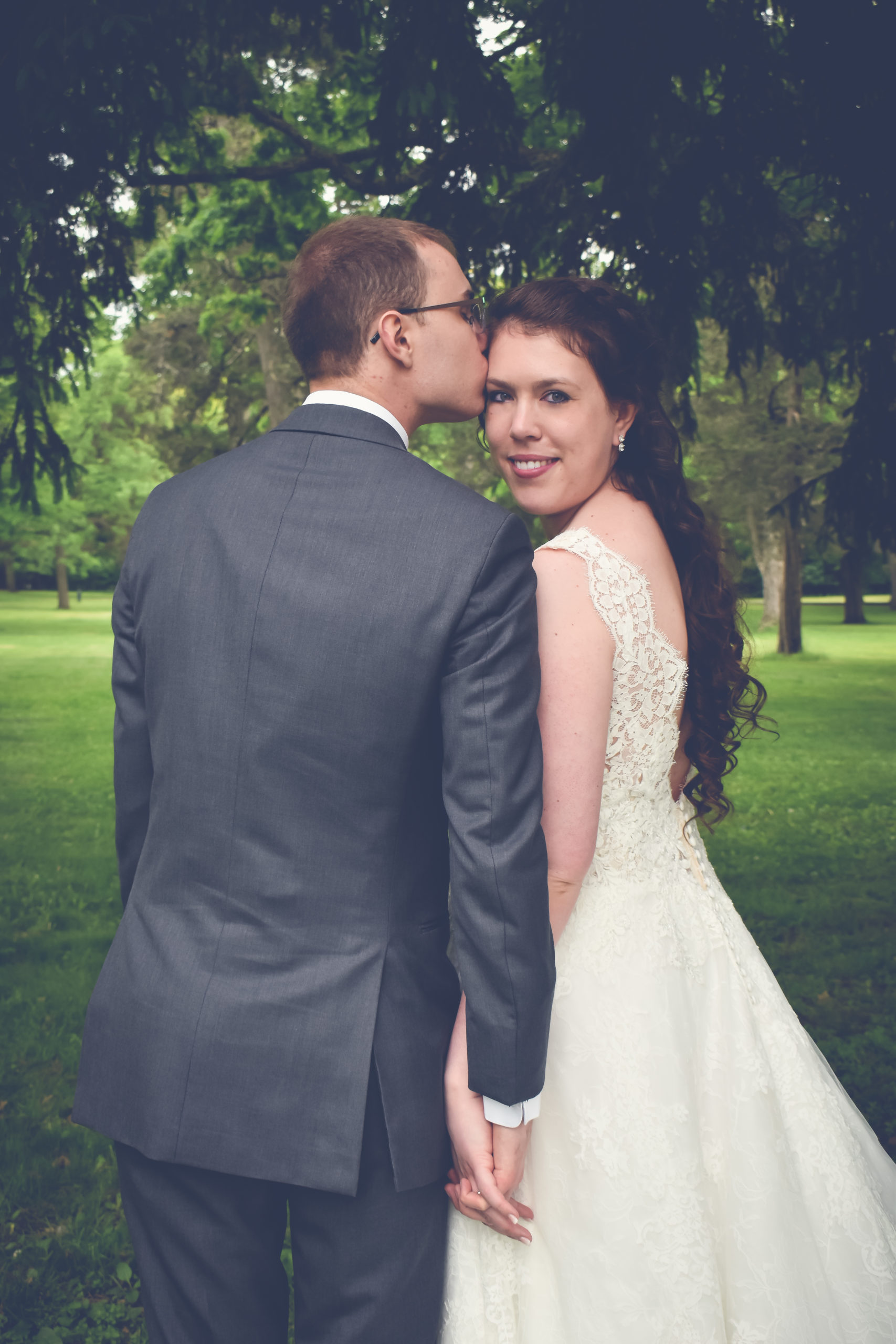 Groom kissing bride on the forehead