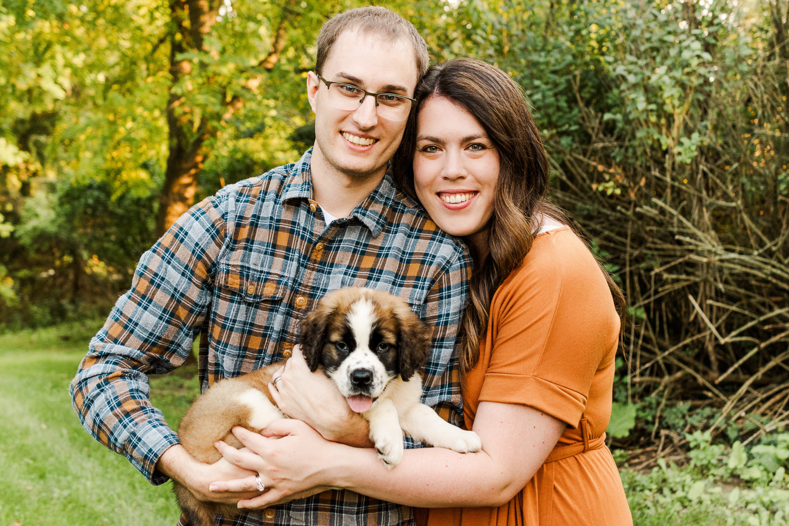 Couple and saint Bernard puppy looking at camera