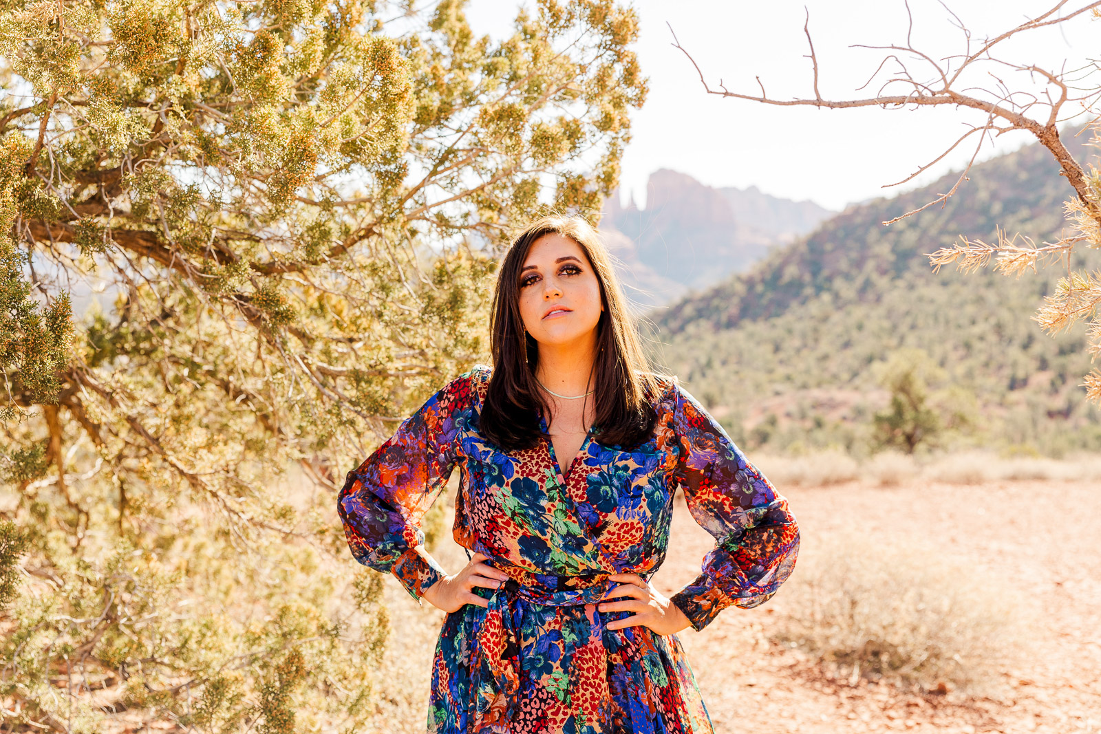 Woman in printed dress standing looking at camera in Sedona, Arizona