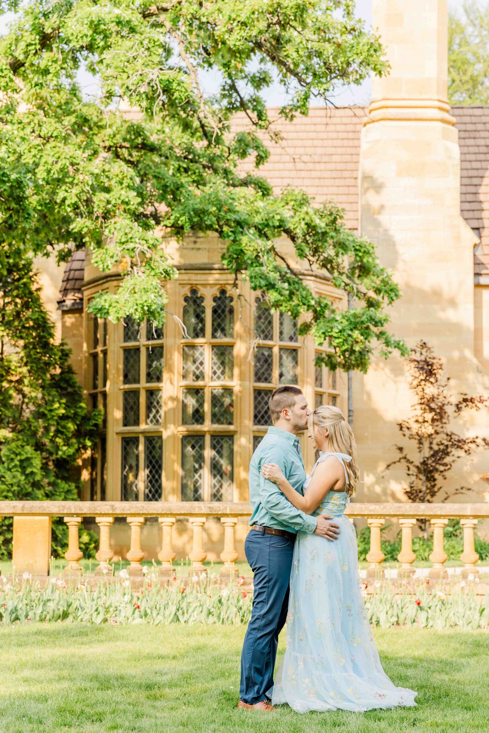 Couple kissing forehead in front of Paine Art Center in Oshkosh Wisconsin.