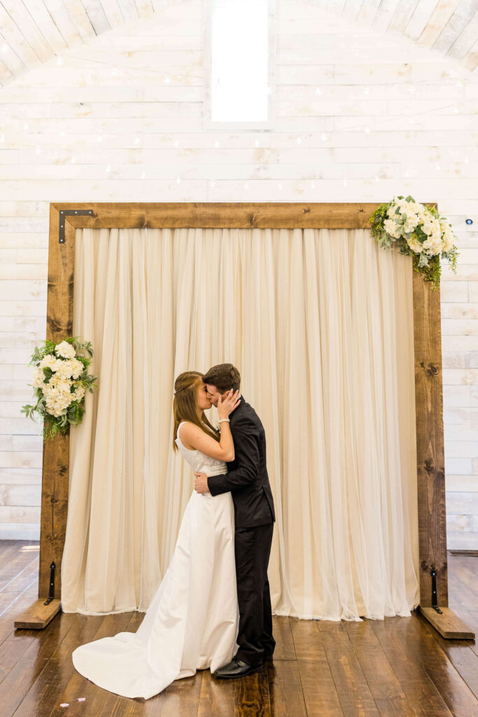 Bride and groom first kiss in the Bowery barn in Wisconsin.