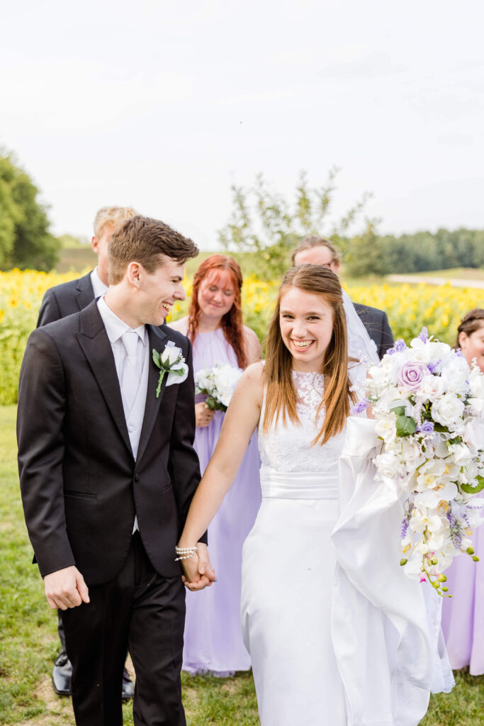 Bride and groom leading the wedding party in front of the Bowery in Wisconsin.