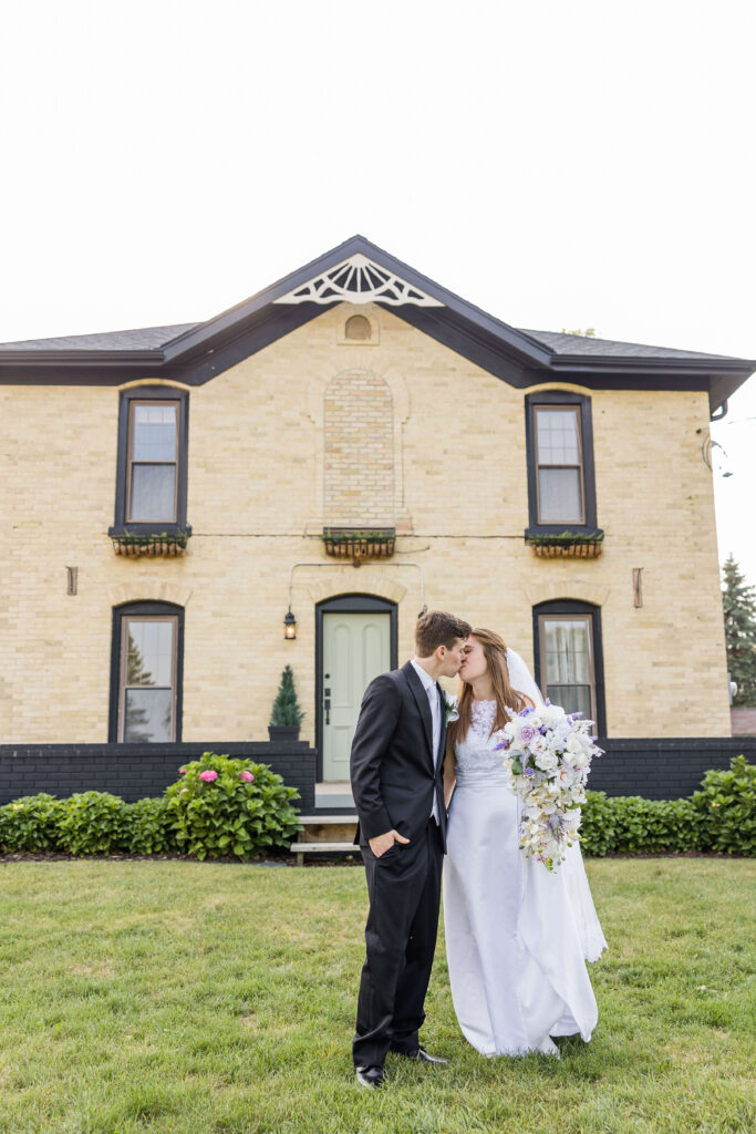 Bride and groom kiss on their August Summer wedding day at the Bowery in Lake country, Wisconsin.