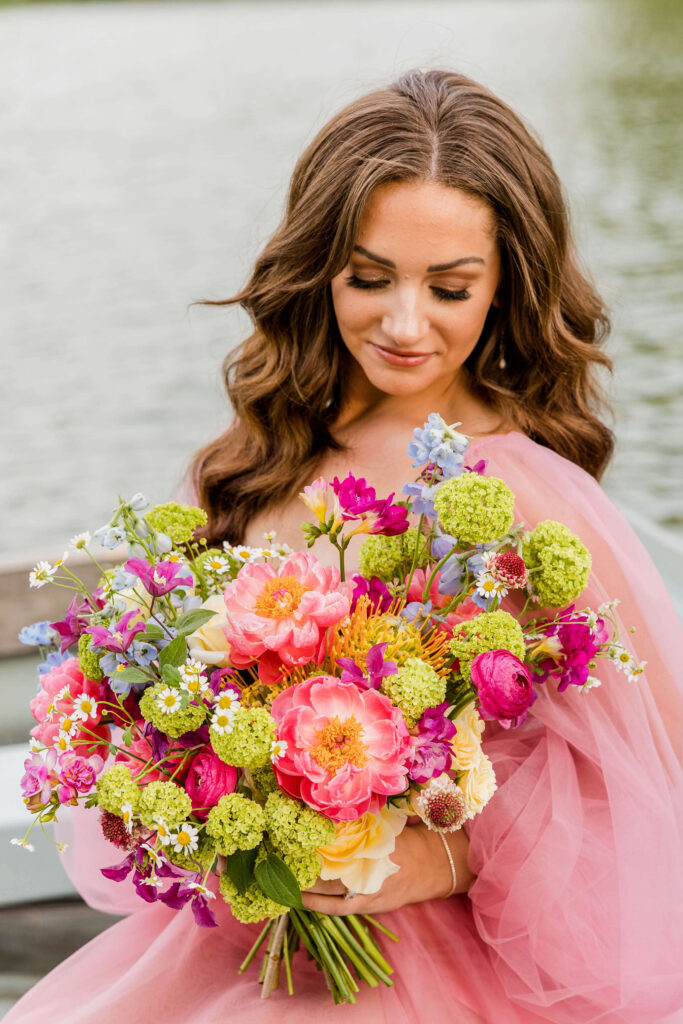 Bride in pink wedding gown in a blue paddle boat on a pond in Waukesha, Wisconsin.