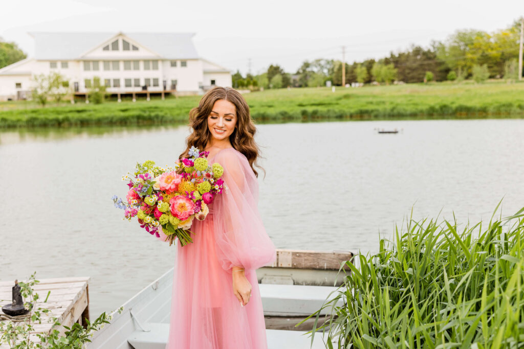 Bride in pink wedding gown in a blue paddle boat on a pond at Fete of Wales in Waukesha, Wisconsin.