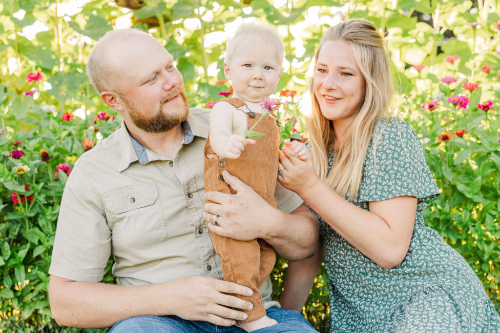 Child picking wildflowers during family portrait session. 