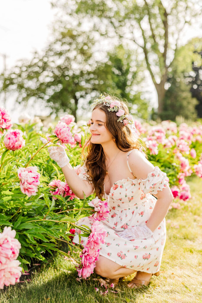 Girl smelling Peony in field. 