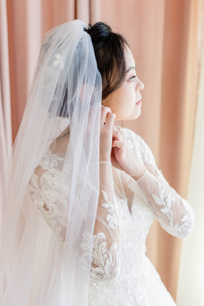 Bride putting on earring 10 South in Wisconsin.