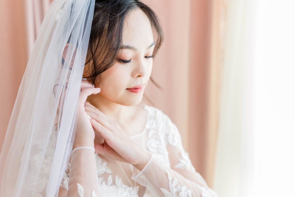 Bride putting on earring.