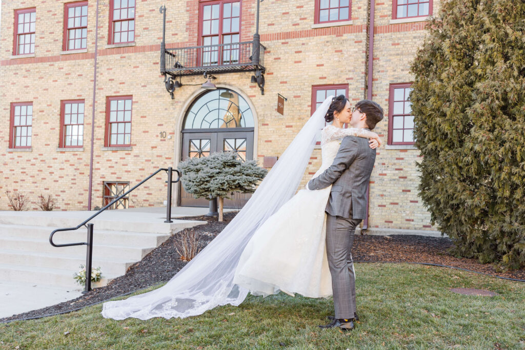 Groom holding bride in front of 10 South in Madison Wisconsin.