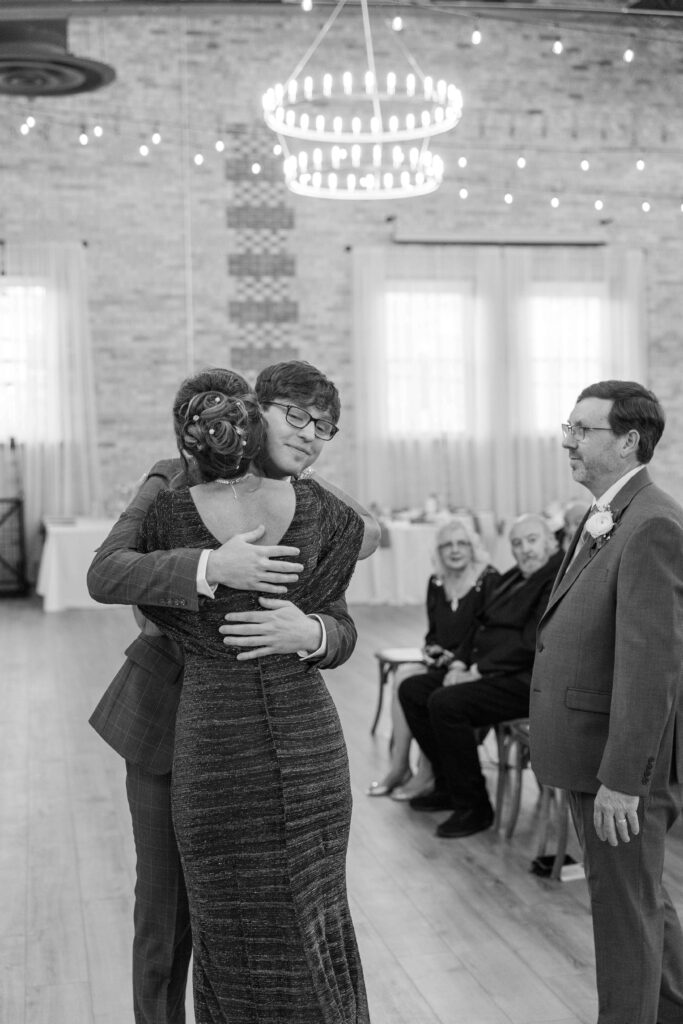 Groom hugging mother during wedding ceremony. 