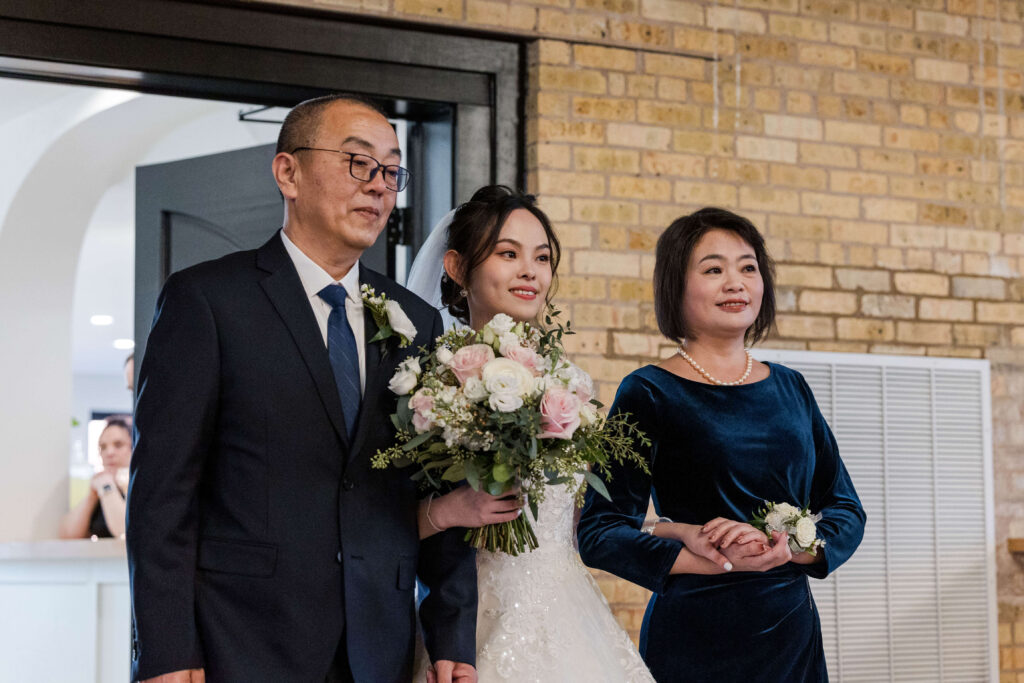 Bride's parents walking her down the aisle.