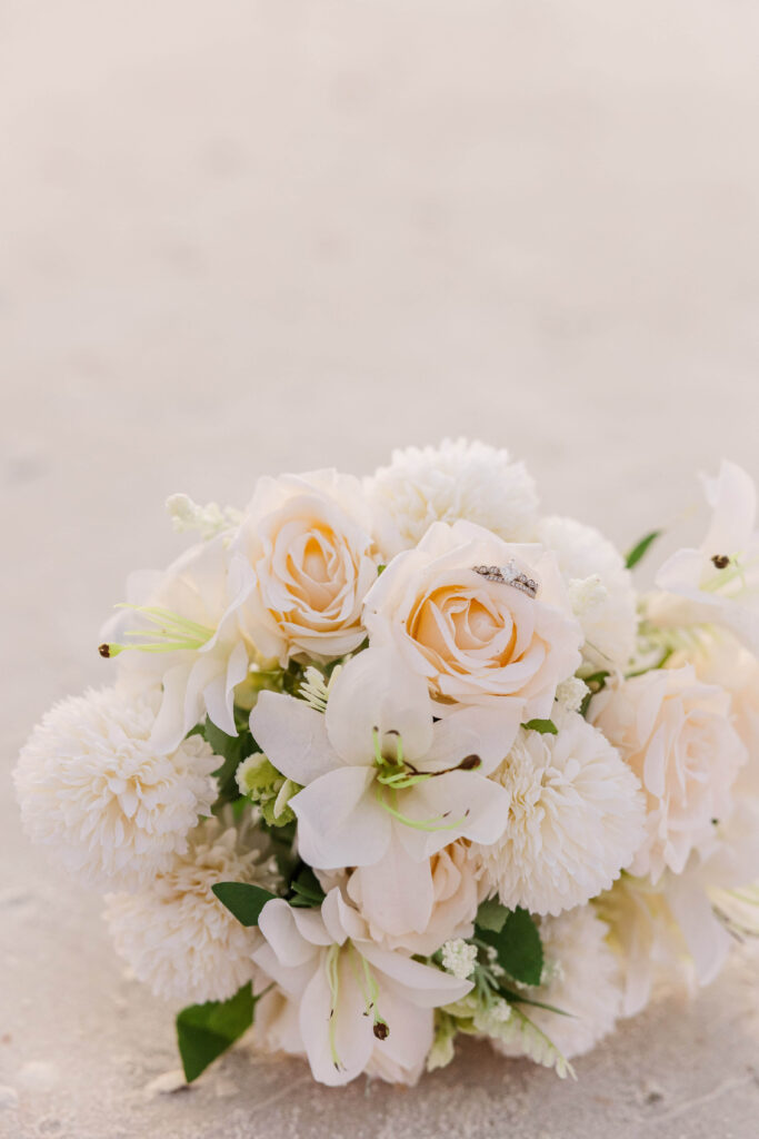 Bridal Bouquet and wedding rings on beach on Honeymoon Beach in Florida. 