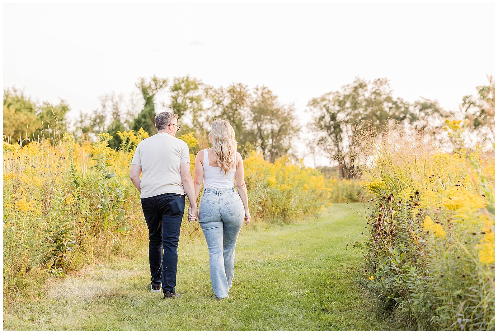 Couple walking through wildflower fields in Wisconsin. 