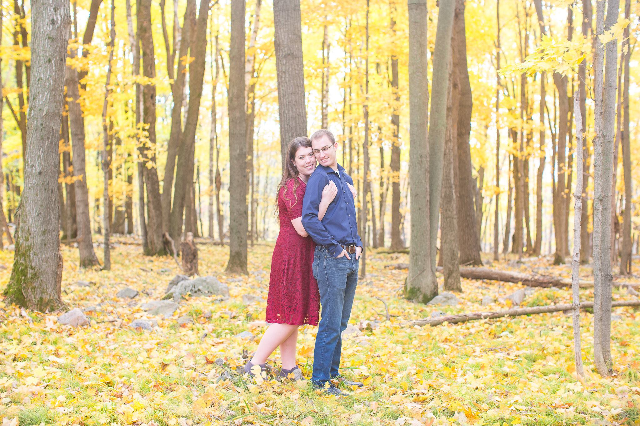 Couple in red and blue surrounded by yellow fall leaves