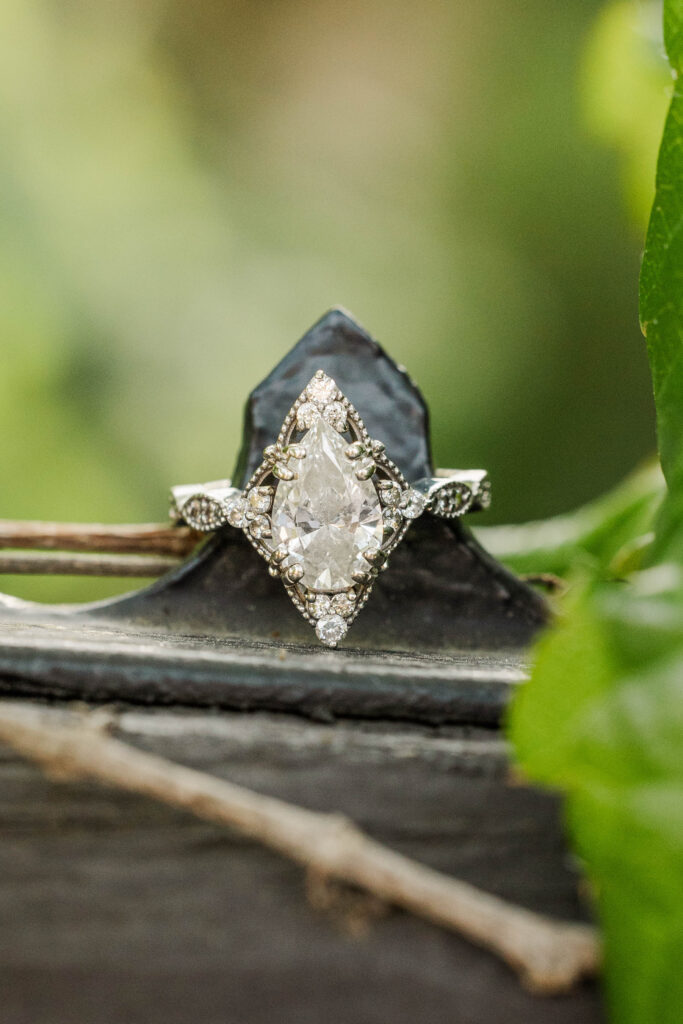 Intricate Diamond Engagement ring placed on iron fence.