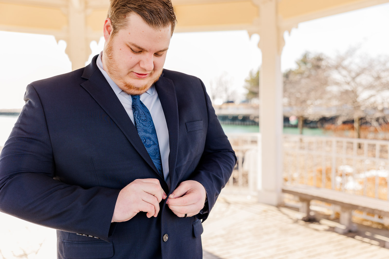 Groom getting ready buttoning coat