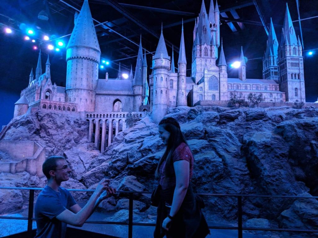Man proposing to woman in front of Harry Potter sets in London, England