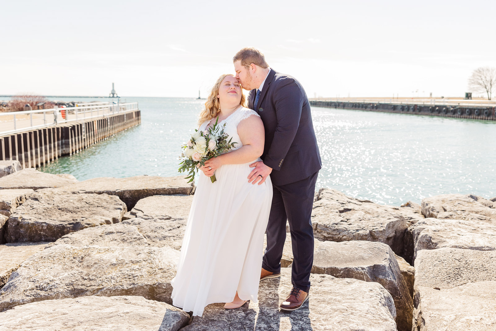 Groom kissing Brides forehead in front of Lake Michigan