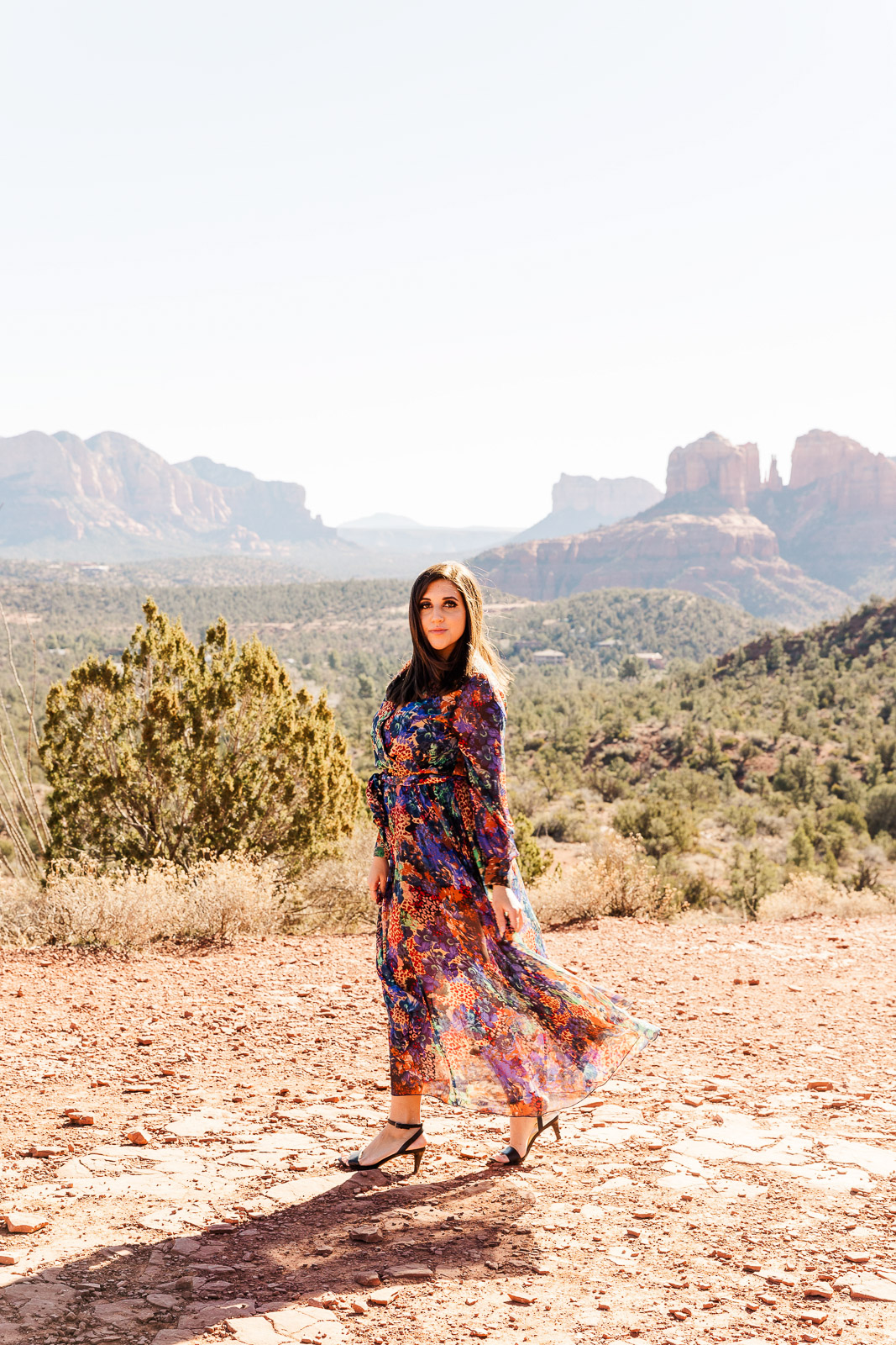 Woman walking, hair blowing in breeze in front of rock formation Sedona Arizona