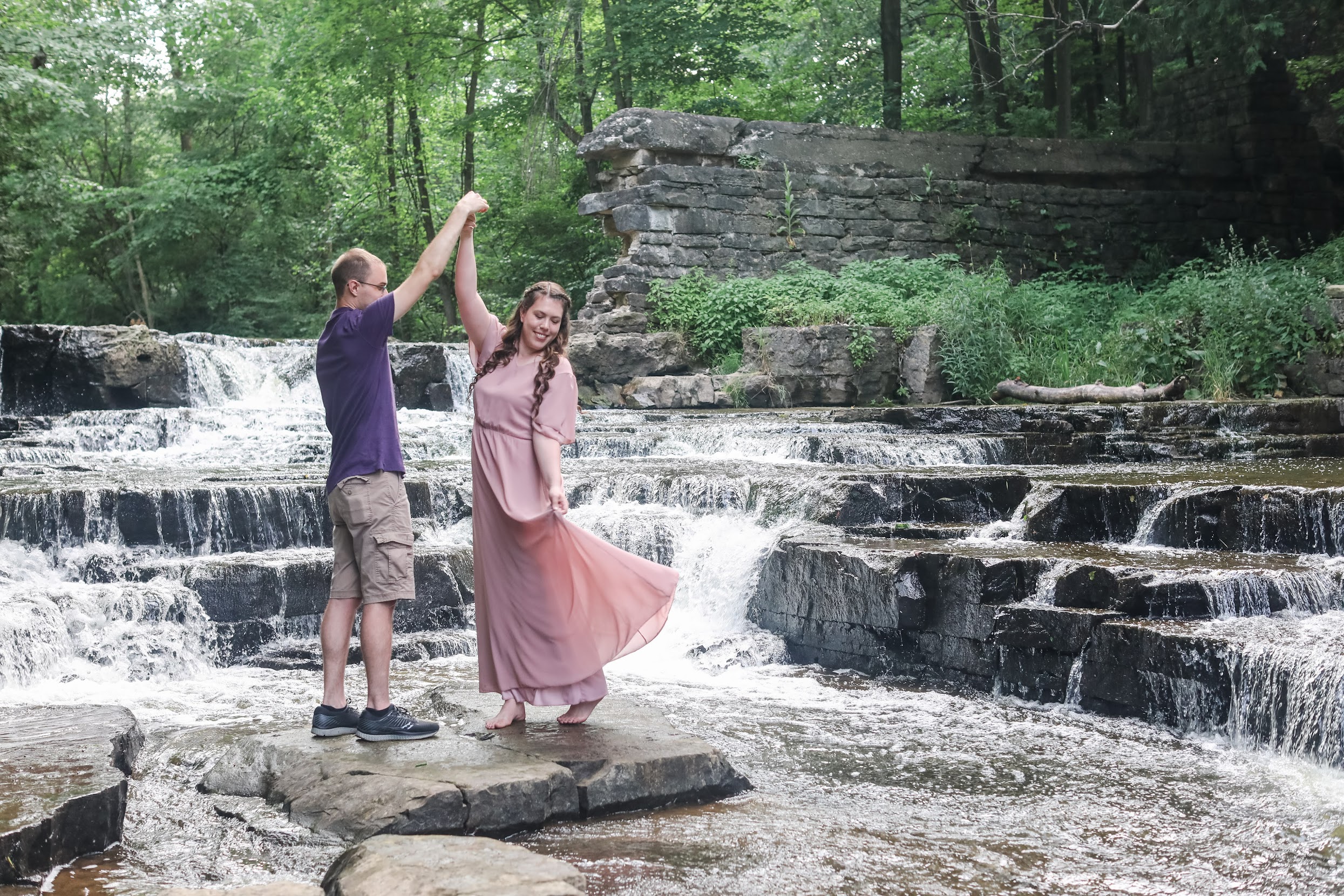 Couple dancing and twirling in waterfall