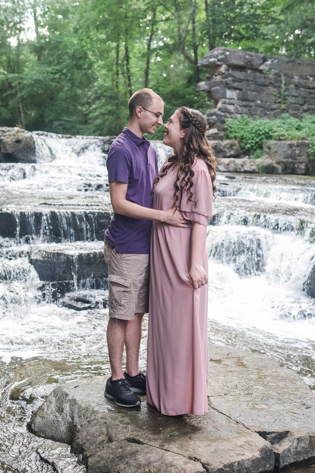 Couple touching noses in front of Waterfall
