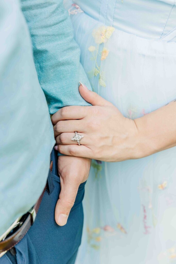 Engagement ring shot against floral dress. 
