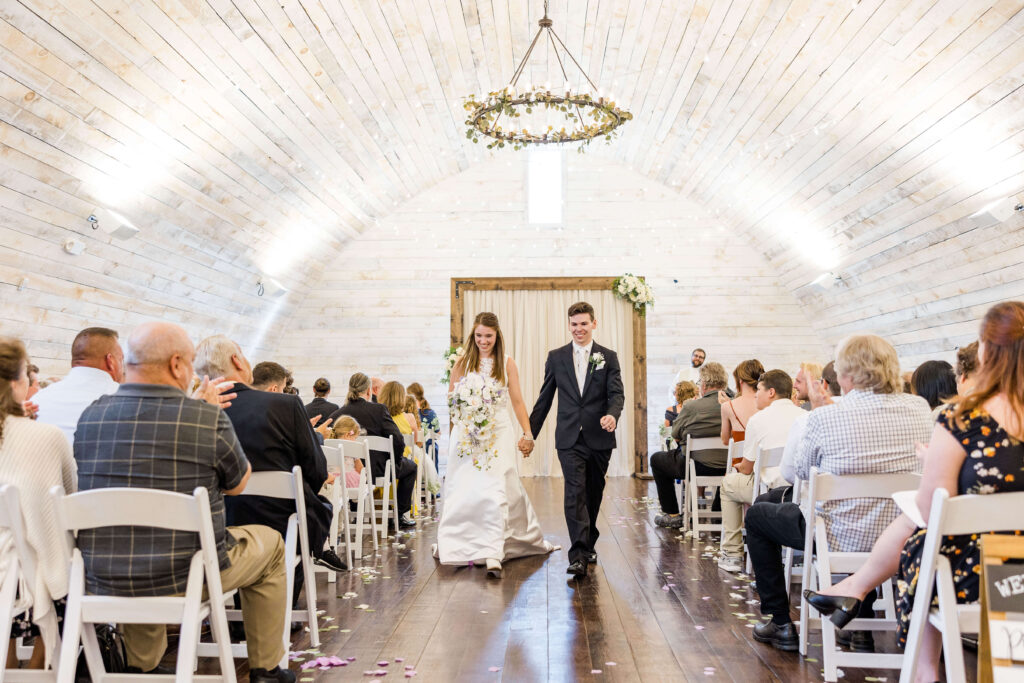 Bride and groom exiting the aisle in the Bowery barn in Wisconsin.
