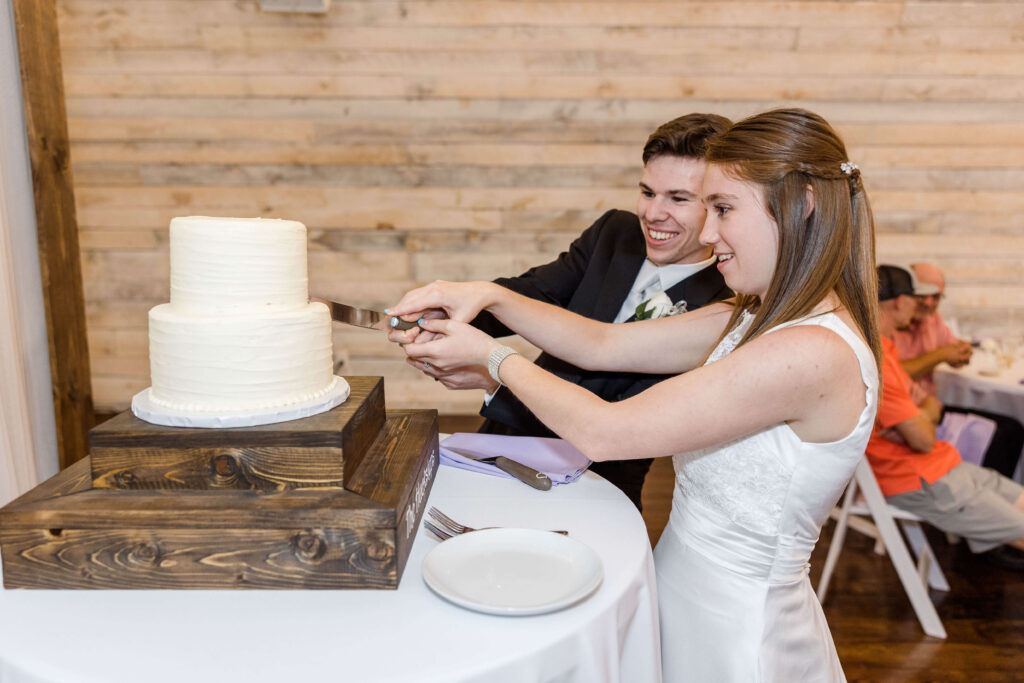 Bride and groom cutting their wedding cake at the Bowery in Lake country, Wisconsin.