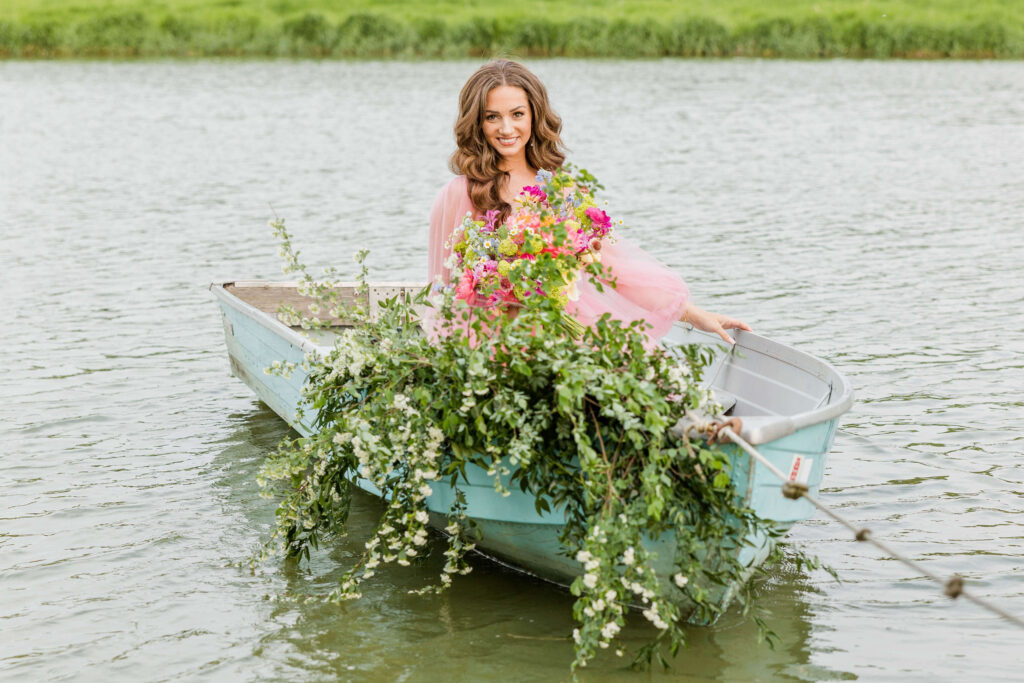 Bride in pink wedding gown in a blue paddle boat on a pond in Waukesha, Wisconsin.
