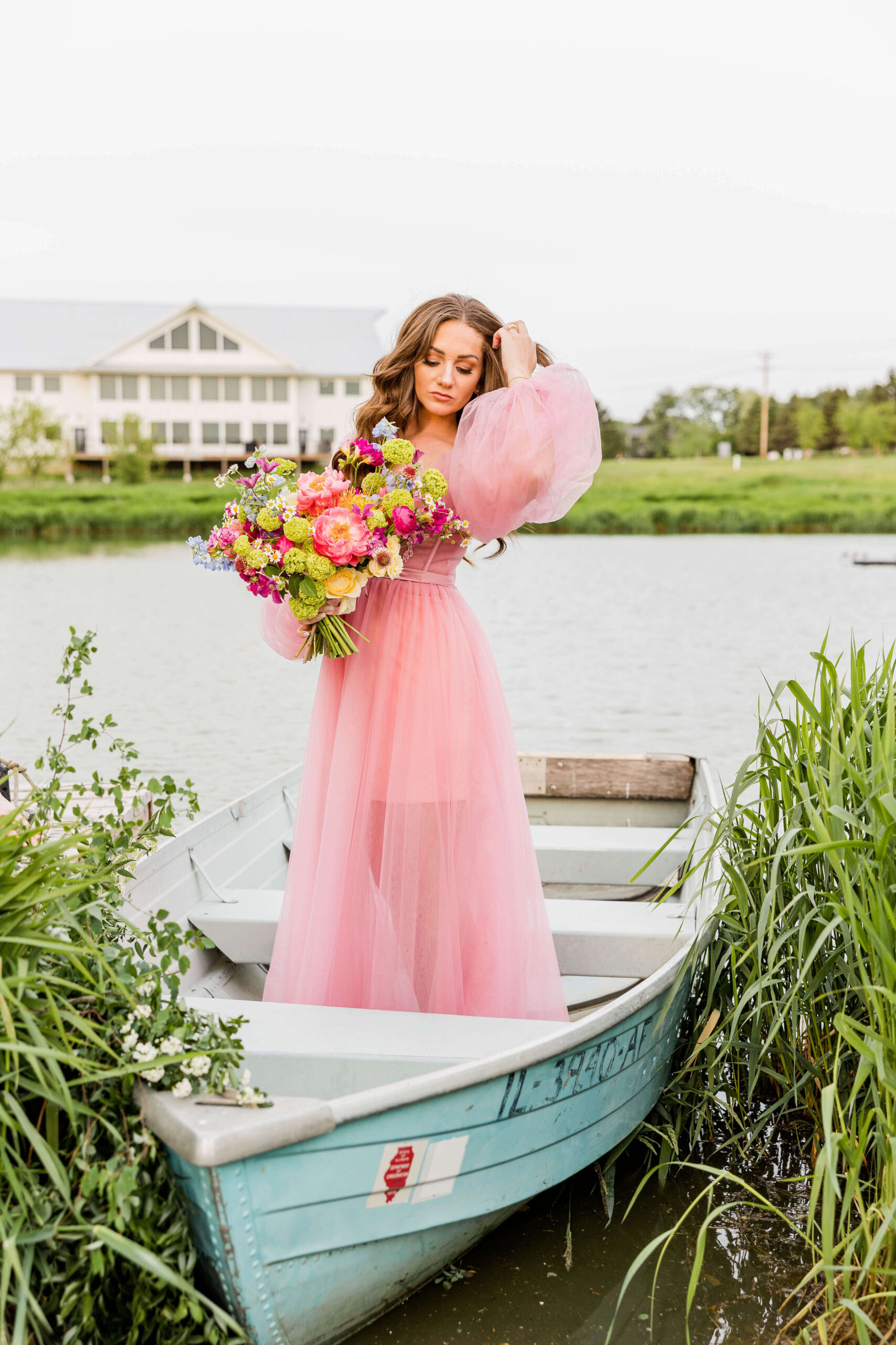 Bride in pink wedding gown in a blue paddle boat on a pond at Fete of Wales in Waukesha, Wisconsin.