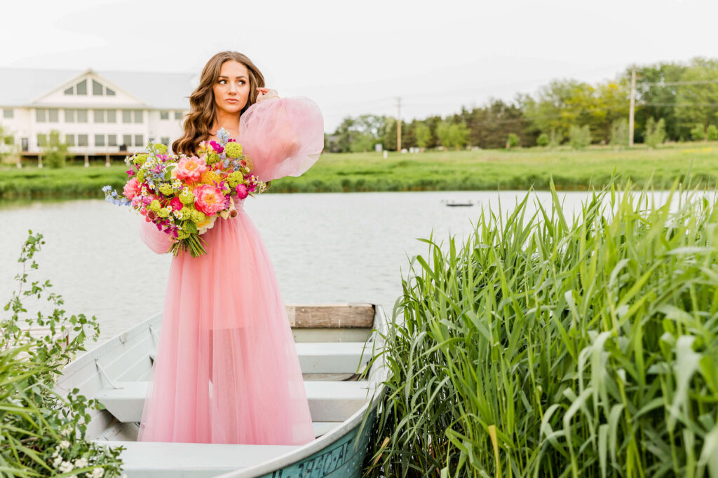 Bride in pink wedding gown in a blue paddle boat on a pond at Fete of Wales in Waukesha, Wisconsin.