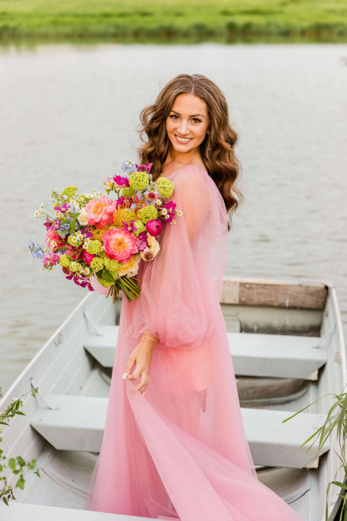 Bride in pink wedding gown in a blue paddle boat on a pond Waukesha, Wisconsin.
