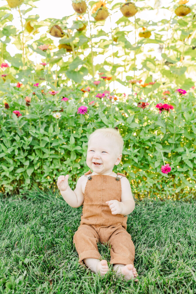 Little boy in overalls laughing with wildflowers in Wisconsin Fall. 