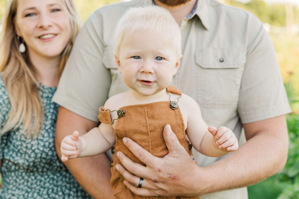 Close up of boy in overalls during a Fall family portrait session. 