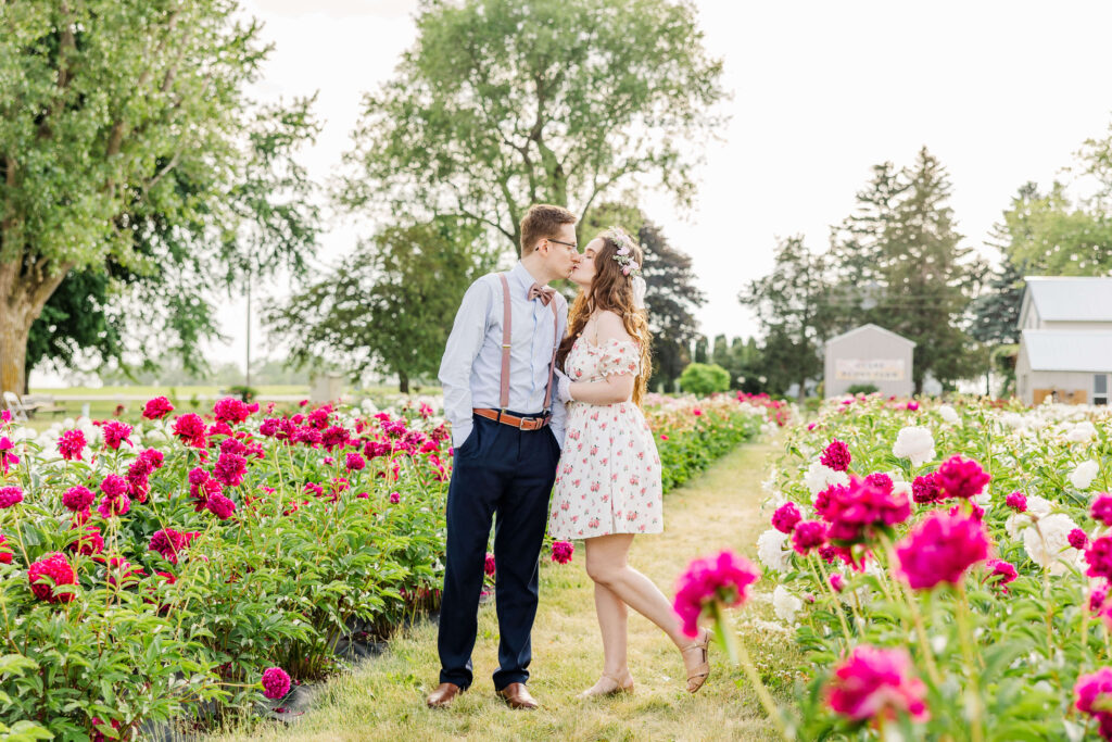Couple kissing at anniversary portrait session Ovans Peony Farm located outside of Madison, Wisconsin. 