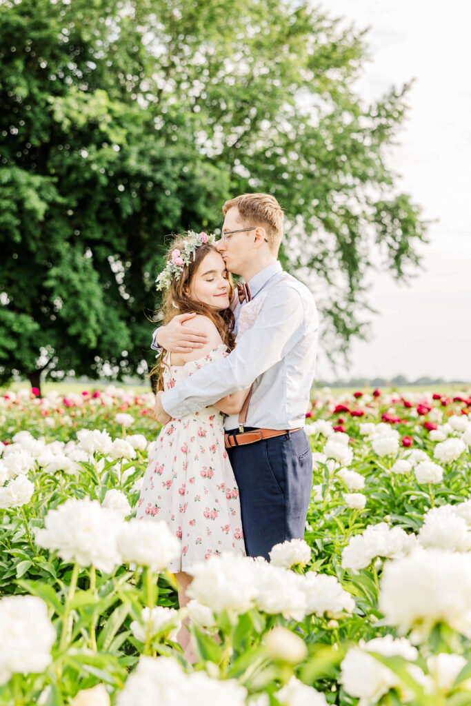 Anniversary couple embracing at Ovans Peony Farm located outside of Madison, Wisconsin. 