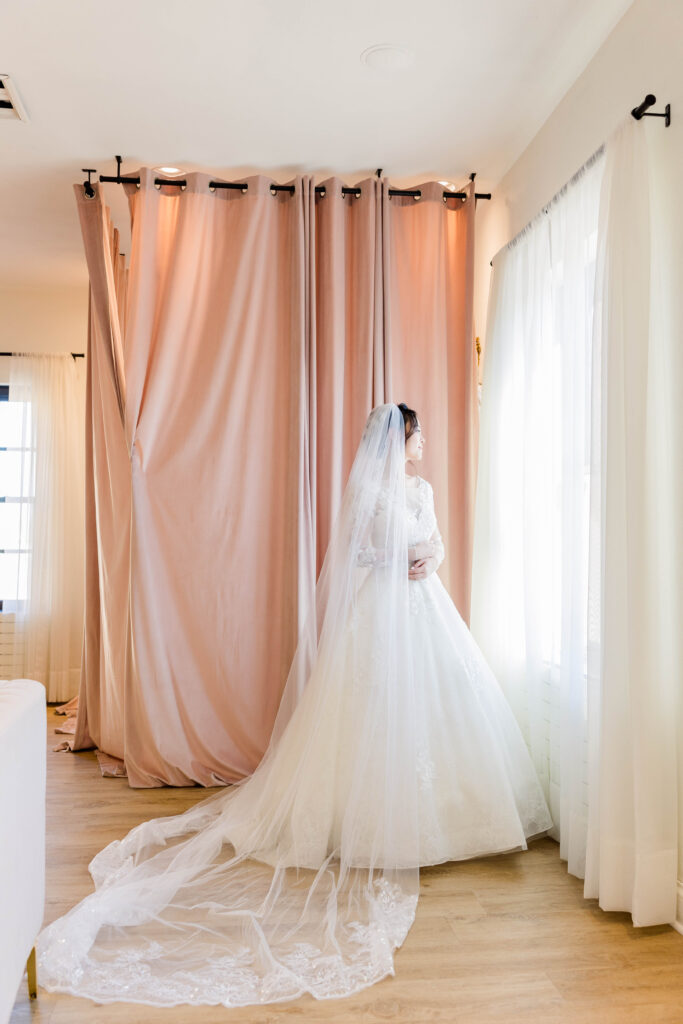 Bride looking out the window in the bridal suite at 10 South in Janesville, Wisconsin.