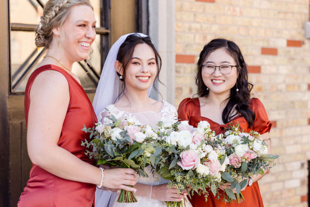 Bride smiling at the camera with bridal party.