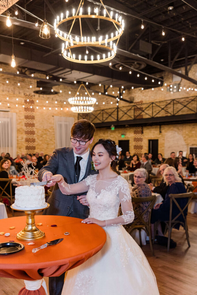 Bride and groom cutting wedding cake. 