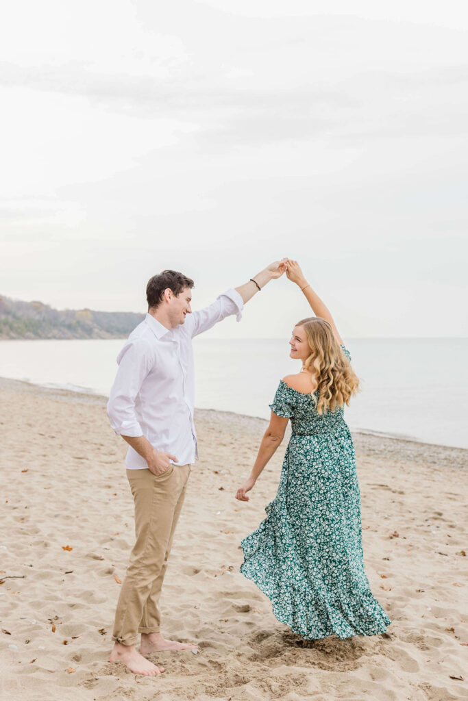 Couple twirling on the beach of Lake Michigan in Milwaukee. 