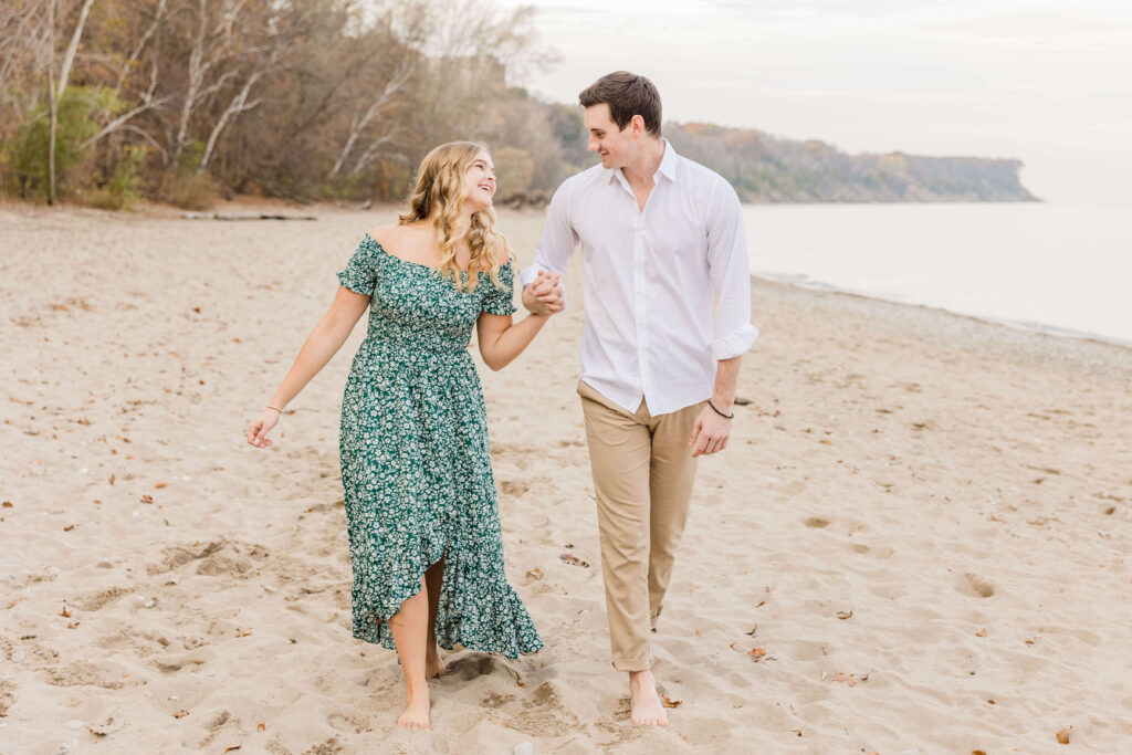 Couple walking on the beach for Engagement session in Milwaukee, Wisconsin. 