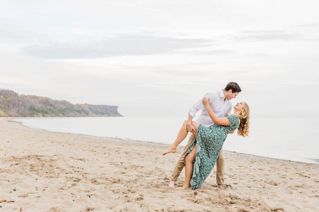 Dip kiss on Lake Michigan beach for Milwaukee Engagement session. 