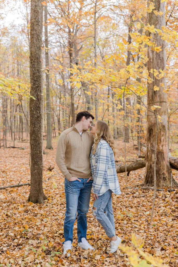 Couple kissing in yellow Fall leaves in Milwaukee, Wisconsin. 